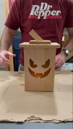 a cardboard box with a face drawn on it and a person standing in the background