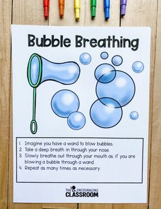 the bubble breathing activity is displayed on a wooden surface with crayons around it