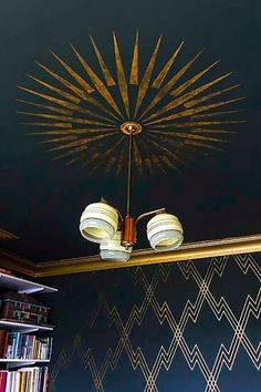 a room with bookshelves and a chandelier hanging from the ceiling in front of a bookcase