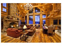 a living room filled with furniture and a fire place in front of a stone fireplace