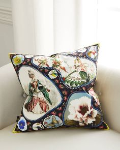 a decorative pillow on a white couch in front of a window