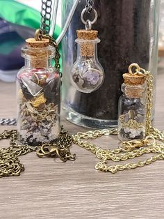 two glass bottles filled with different types of items on a table next to a chain