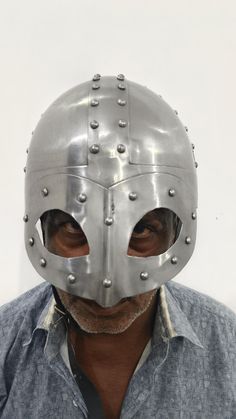 a man wearing a metal mask with rivets on his face