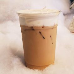 a cup of coffee sitting on top of snow covered ground