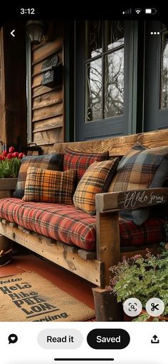 a couch sitting on top of a wooden floor next to a window filled with flowers