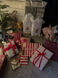 many wrapped presents sitting on the floor next to a christmas tree