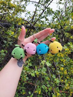 four crocheted keychains in the shape of animals hanging from a tree