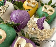 an assortment of mardi gras decorations in a white container with green and yellow apples