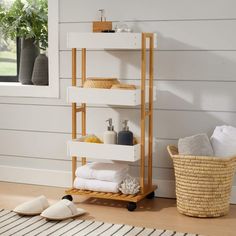 a shelf with towels and other items on it in front of a white painted wall