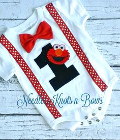 a baby bodysuit with a red bow tie and the number one on it's chest