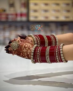 a woman's hands with hennap and bracelets on display in a store