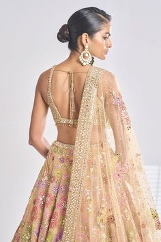 Gold attached can-can lehenga features multi-coloured floral applique highlighted with mirror, sequin, and crystals. Paired with blouse in all-over gold mirror embroidery. Comes with dupatta in mirror border and floral applique all-over.
Component: 3
Pattern: Embroidered
Type Of Work: Floral
Neckline: Plunge V Neck
Sleeve Type: Sleeveless
Fabric: Net
Color: Gold
Other Details: 
Floral embroidery
Padded blouse
Attached can-can lehenga
Embroidered dupatta
Back tie-up
Occasion: Wedding,Bride - Aza Multicolor Sleeveless Choli For Wedding, Sleeveless Multicolor Wedding Choli, Multicolor Wedding Choli With Sheer Dupatta, Sleeveless Multicolor Lehenga For Wedding, Golden Lehenga, Sequin Lehenga, Seema Gujral, Mirror Border, Gold Lehenga