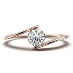 a rose gold ring with a round diamond in the center and two thin bands around it