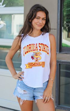 Love a cute tank top for game day?! This "Florida State" Vintage Curve Hem Tank is the cutest style - great for moms and daughters alike! Whether you keep it casual with cute jean shorts or dress it up with your favorite skirt - this sleeveless tank is the perfect choice for those Tallahassee game days at Doak. Details: *OFFICALLY LICENSED* Vintage Washed Cotton Tank 100% Cotton Crew Neckline, Sleeveless, Full Length with curved hemline, Bra Friendly Features a Vintage FSU Logo with Garnet & Gol Summer Collegiate Top For College, College Spirit Tops For Spring, School Spirit Tops For College Spring Season, Trendy Tops For Game Day In Summer, Casual Sleeveless Tank Top For College, Collegiate Sleeveless Tops With Letter Print, White School Spirit Top For Spring, Summer Game Day Tops With Letter Print, Summer Cheerleading Tops With School Spirit Style