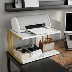 a laptop computer sitting on top of a wooden desk next to a printer and monitor