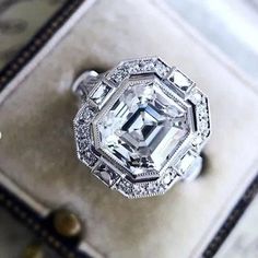 an old - fashioned diamond ring sits on top of a box