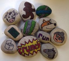 a bunch of rocks that have some pictures on them with words painted on them in different colors