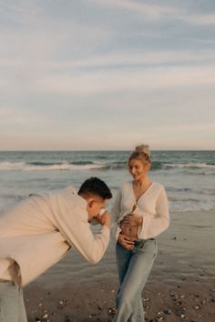 a man and woman standing on the beach