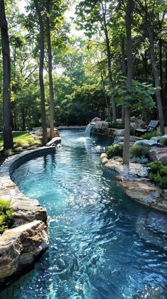 an outdoor swimming pool surrounded by trees and water features a waterfall that runs down to the ground