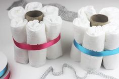 several rolls of toilet paper are tied together with blue and pink ribbons on a white surface