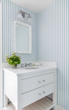 a bathroom with blue and white striped walls