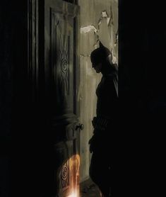 a person standing in front of a door with a light at the end of it