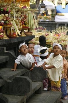 several children are standing on steps in front of an outdoor market