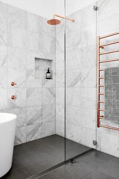 an image of a bathroom with marble walls and flooring, including the shower area