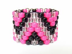 a pink and black bracelet is stacked on top of each other