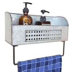 a metal shelf with two soaps and lotion bottles on it next to a blue towel