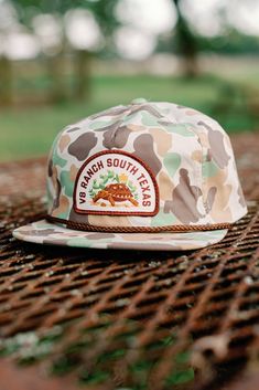 Introducing the V8 Ranch South Texas Cap, inspired by the rugged beauty of the South Texas brush country. This cap features a poly fabric in a unique frog skin camo print, reminiscent of caps from the 1980s and 1990s. The 5-panel Original Fit design includes a stand-up mesh stay for added comfort and breathability. It comes with a performance moisture-wicking sweatband to keep you cool and dry. The cap is adorned with a patch showcasing V8 Ranch South Texas, featuring the Texas Tortoise, an enda Branded Caps, South Texas, New T, Camo Print, Hoodie Top, Gift Stickers, Sticker Shop, Tortoise, Kids Accessories