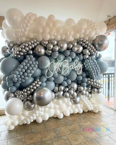 a large balloon wall with silver and white balloons