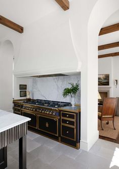 a kitchen with marble counter tops and an oven in the center, along with a dining room table