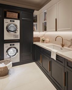 a washer and dryer sitting in a kitchen next to a counter with baskets on it