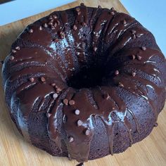 a chocolate bundt cake sitting on top of a wooden cutting board