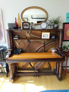 an old piano is sitting in front of a mirror