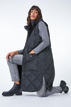 Diamond Quilted Longline Gilet from Roman. Stylish layering has never been more simple with this Roman quilted longline gilet! Designed with a warm high neckline, this casual coat is sure to see you through Autumn and Winter in style. This gilet is crafted with a drawstring hood, fully lined body and diamond quilted design to ensure a flattering and functional fit. It features popper-fastened pockets at the front for all of your essentials. Pair with cosy knitted jumpers, jeans and boots for dog walks and family day trips this season. Hooded Gilet, Frills And Ruffles, Evening Tops, Oasis Fashion, Petite Tops, Style Cardigan, Diamond Quilt, Casual Coat, Knit Jumper