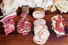 several different types of meat on a cutting board