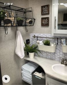 a bathroom with two sinks and hanging baskets on the wall