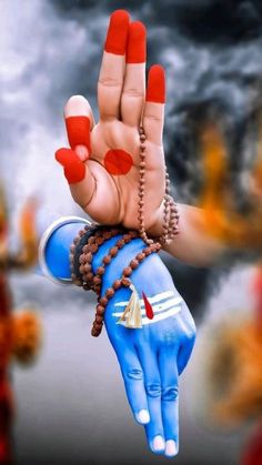 a person's hand with red painted nails and bracelets holding up the palm