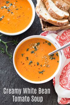 two bowls of creamy white bean tomato soup on a table with bread and napkins