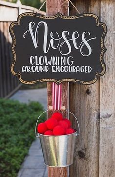 a metal bucket filled with red pom - poms hanging from a wooden pole