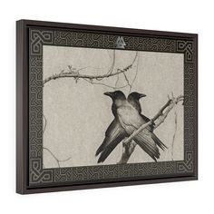 two birds sitting on top of a tree branch in front of a wall hanging frame