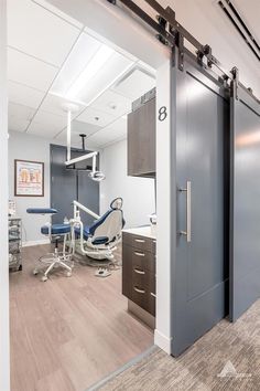 an office with dental equipment in the background and open doors leading to another room that also has a dentist's chair