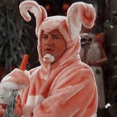 a man dressed in pink bunny costume holding a carrot