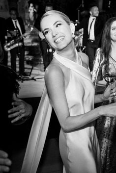 black and white photograph of woman in evening dress at party with band members behind her