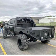 the truck is parked on the side of the road with two people standing around it