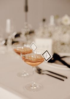 two glasses filled with liquid sitting on top of a table