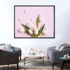 a living room with two gray chairs and a coffee table in front of a pink wall