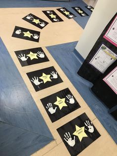 handprints and stars on the ground in front of a bulletin board